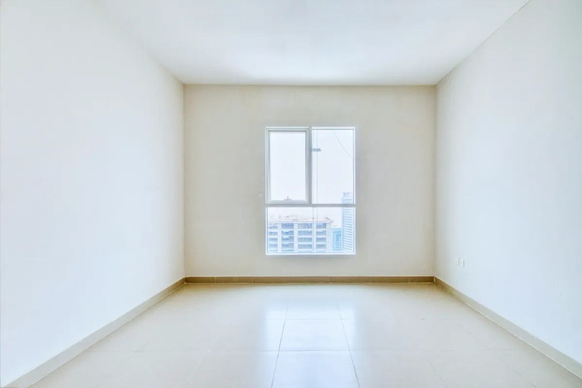 Unfurnished hallway with a wood floor and one window